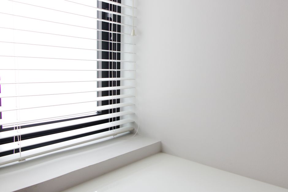 Professional measuring a window for custom blinds installation